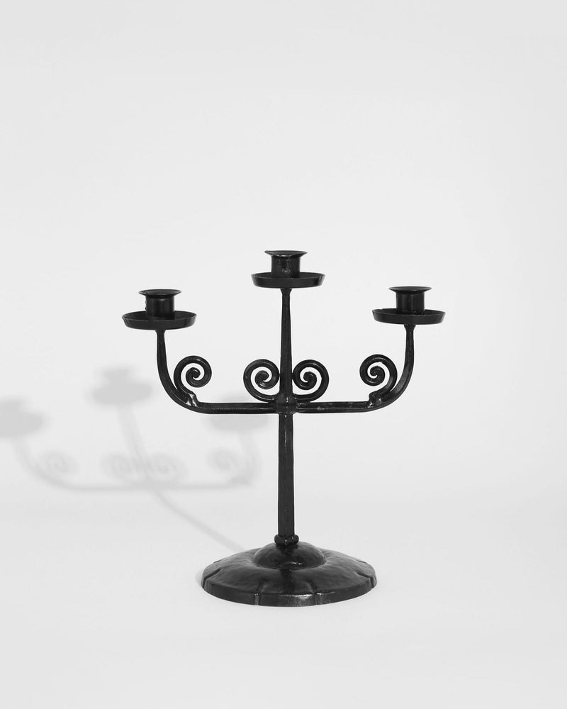 Black iron spiral candelabra with three candle holders on round base