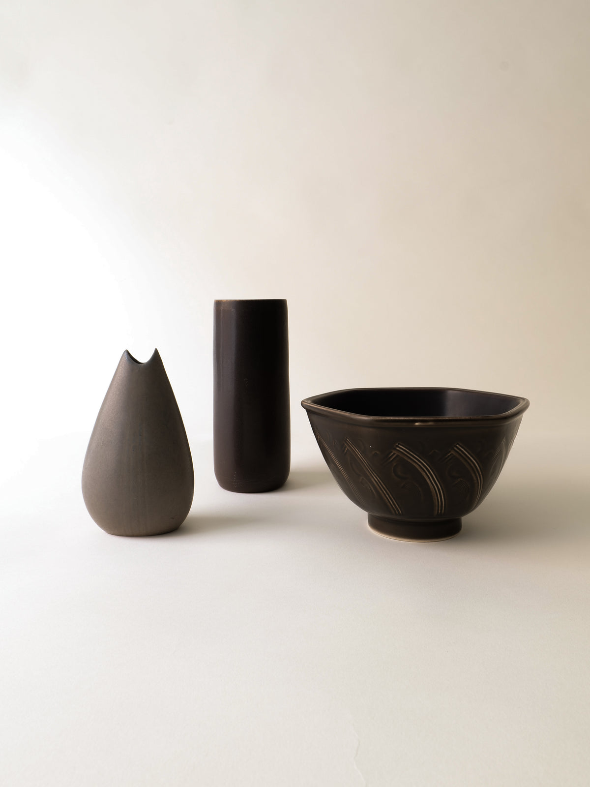 Three dark ceramic vessels including Gunnar Nylund 1950s vase