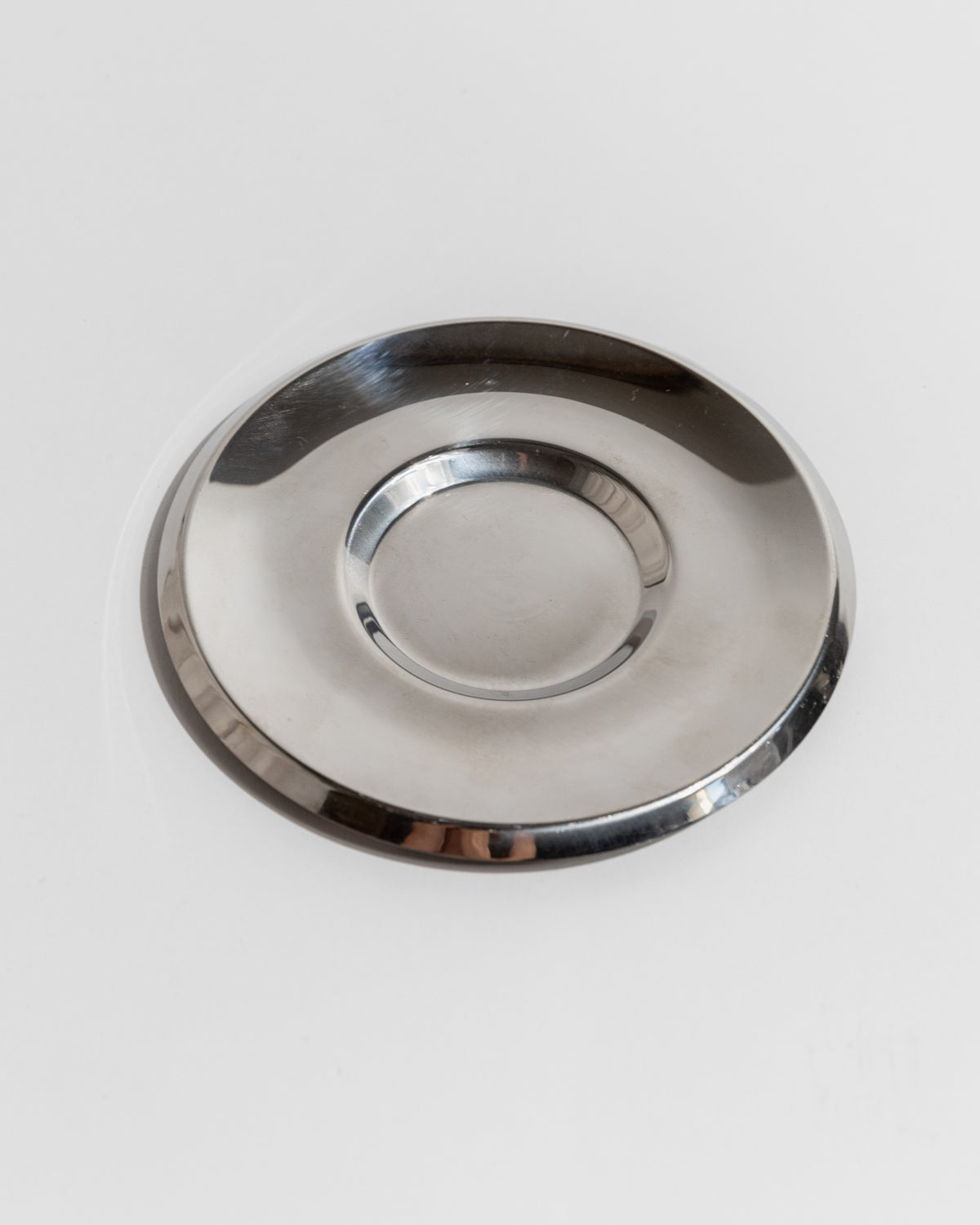 Vintage stainless steel coffee saucer, top view on white background