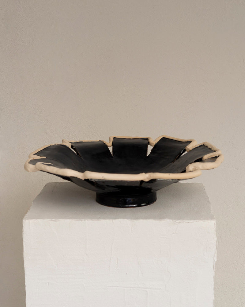 Navy blue ceramic decorative dish with sculptural ruffled edge on pedestal
