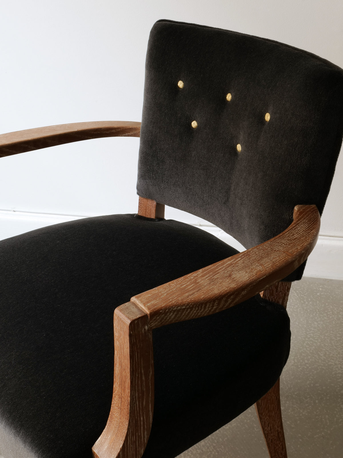Detail view of 1930s French bridge chair showing brass studs and wood frame