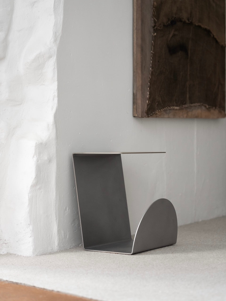 Side Table - 1.0 - Stainless Steel — angled view against textured wall