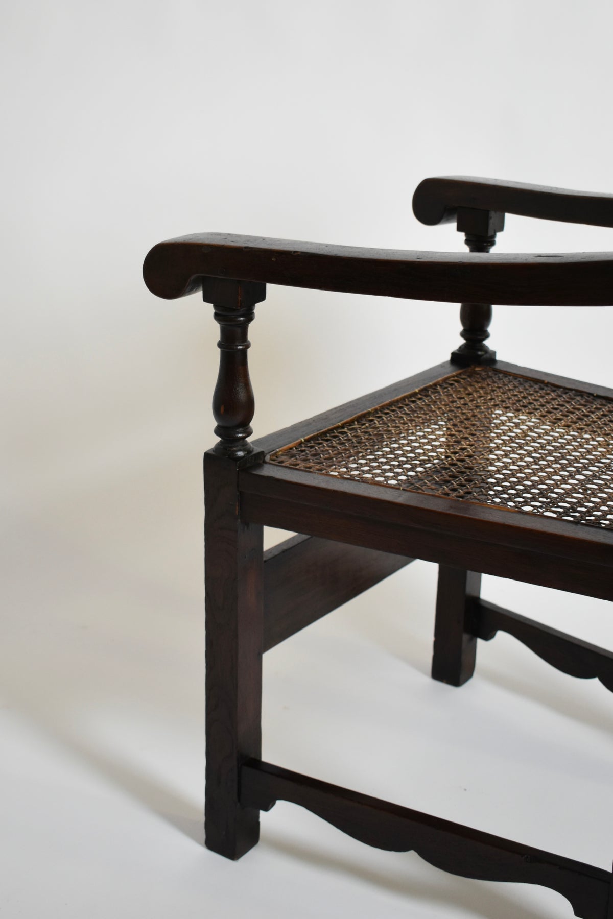 Pair of turned wood and cane armchairs, 1910s — side angle highlighting cane seat and wooden armrest