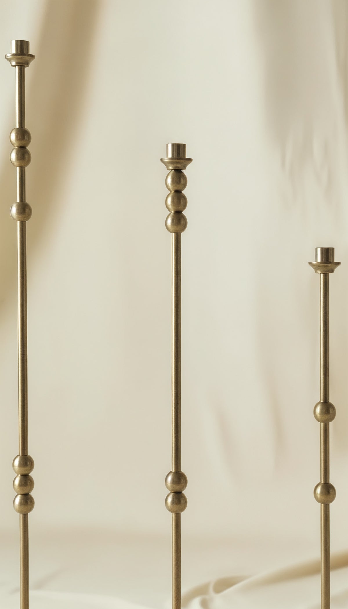 ASHA I – Brushed Brass Sculptural Candlestick Set — front view with three varying heights