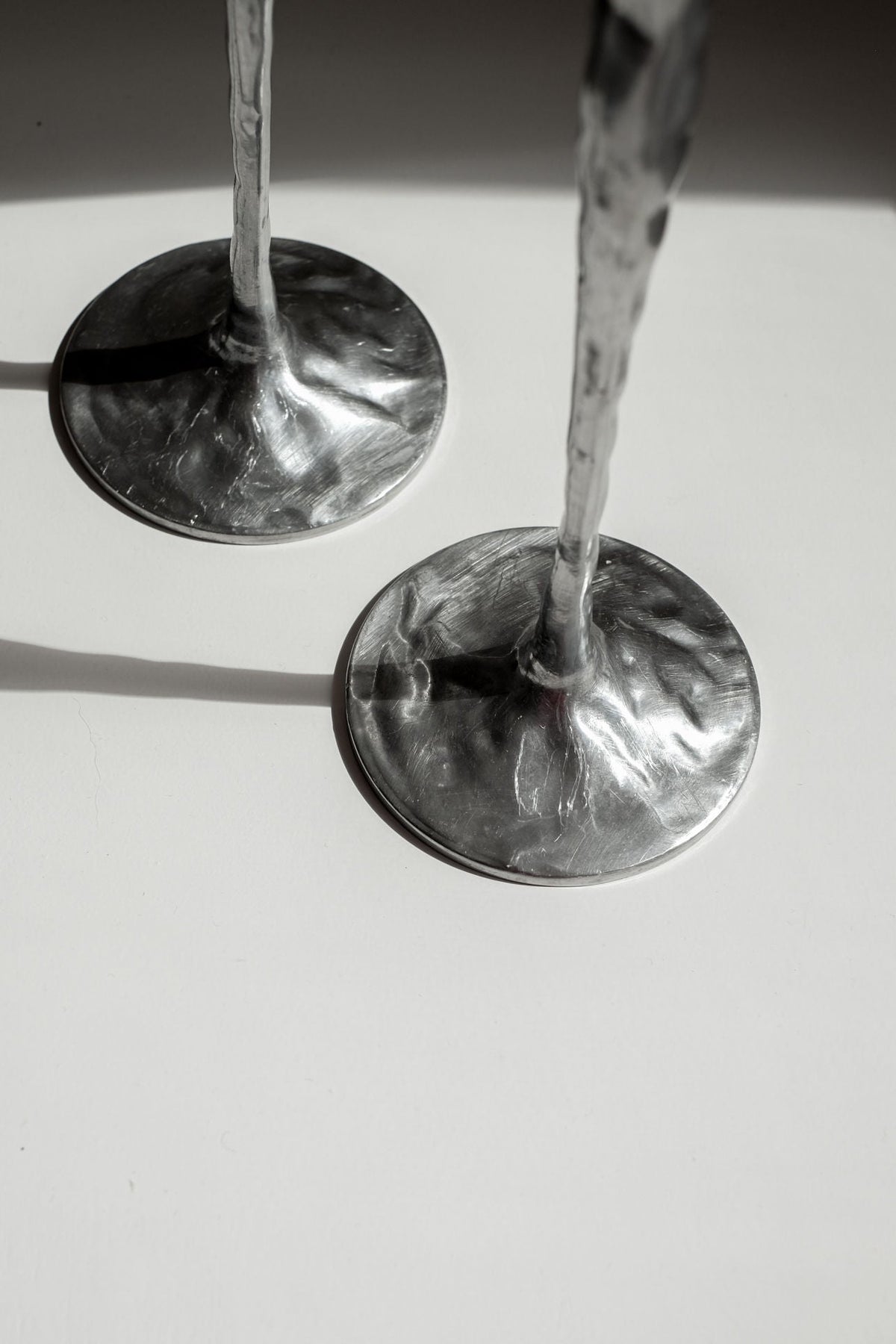 Pair of Aluminium Candle Holders — back view showing textured bases on white surface
