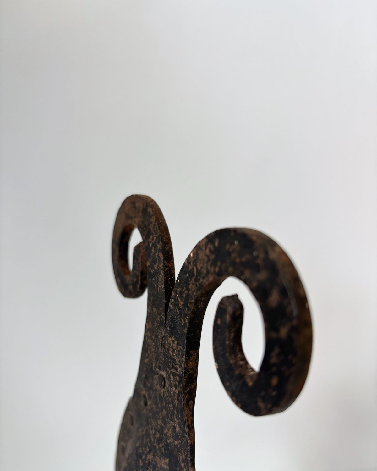Hand-forged iron candleholder curved spiral detail close-up