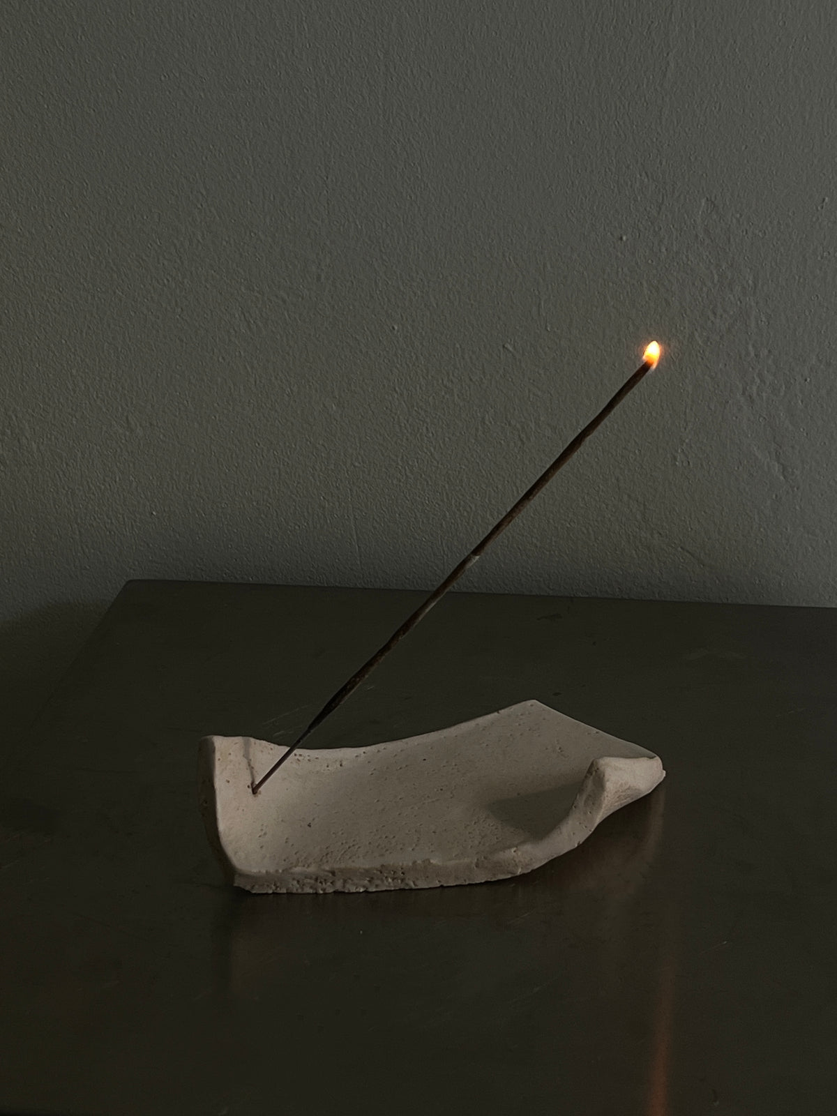 Minimalist concrete incense holder with burning stick by 2222Studio