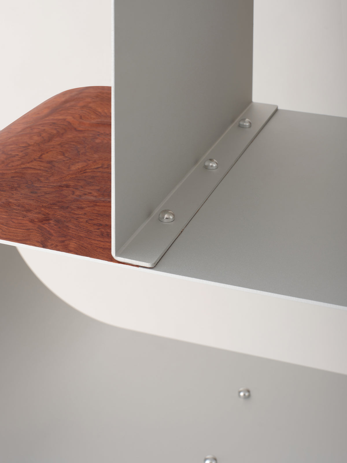 Aluminum shelf with wood detail and metal fasteners close-up