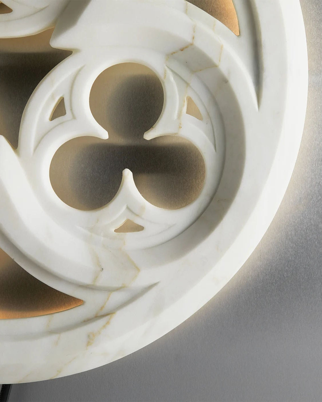 Close-up detail of white tracery wall lamp Gothic quatrefoil pattern