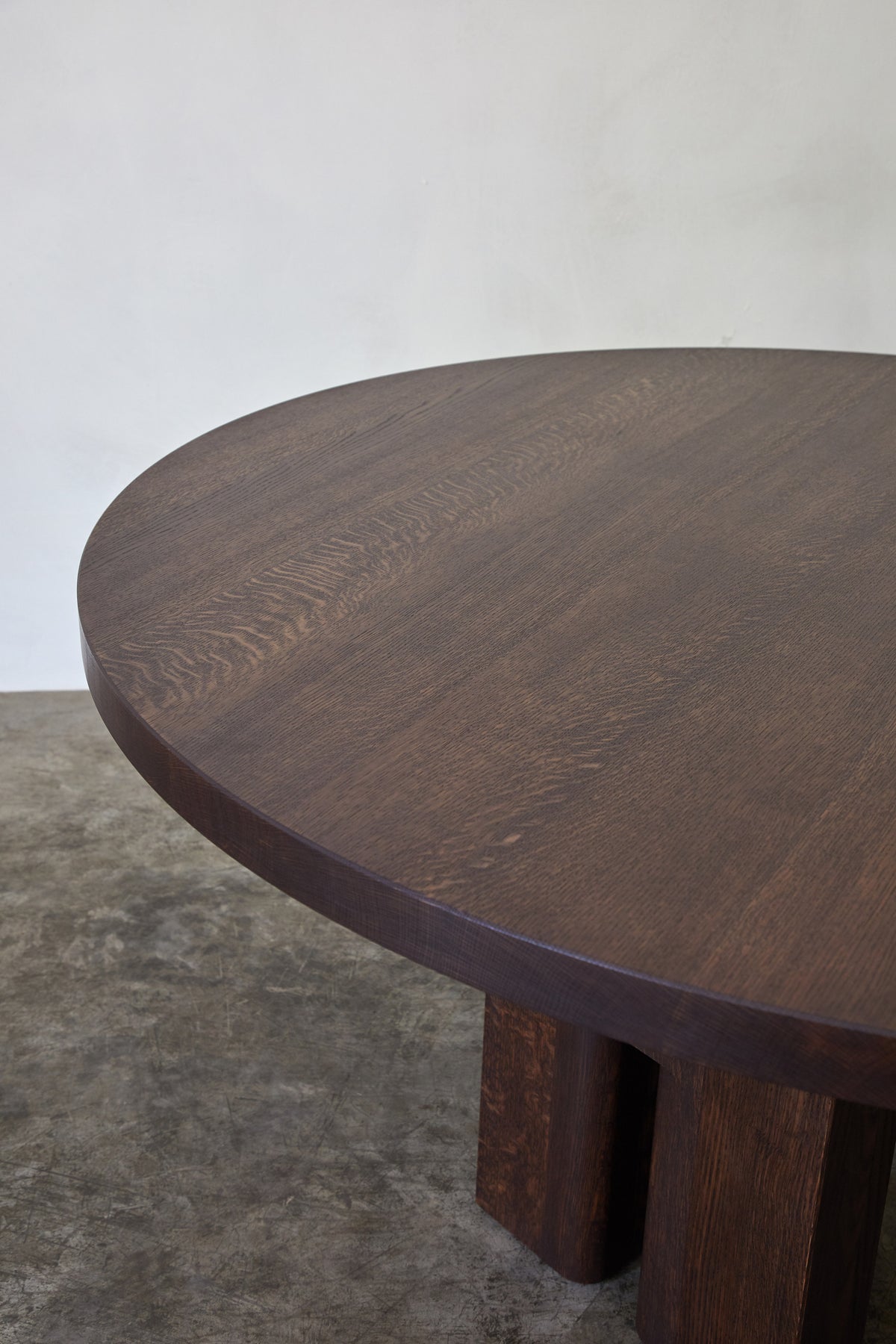 Tulia Round Dining Table — close-up of dark wood surface and legs