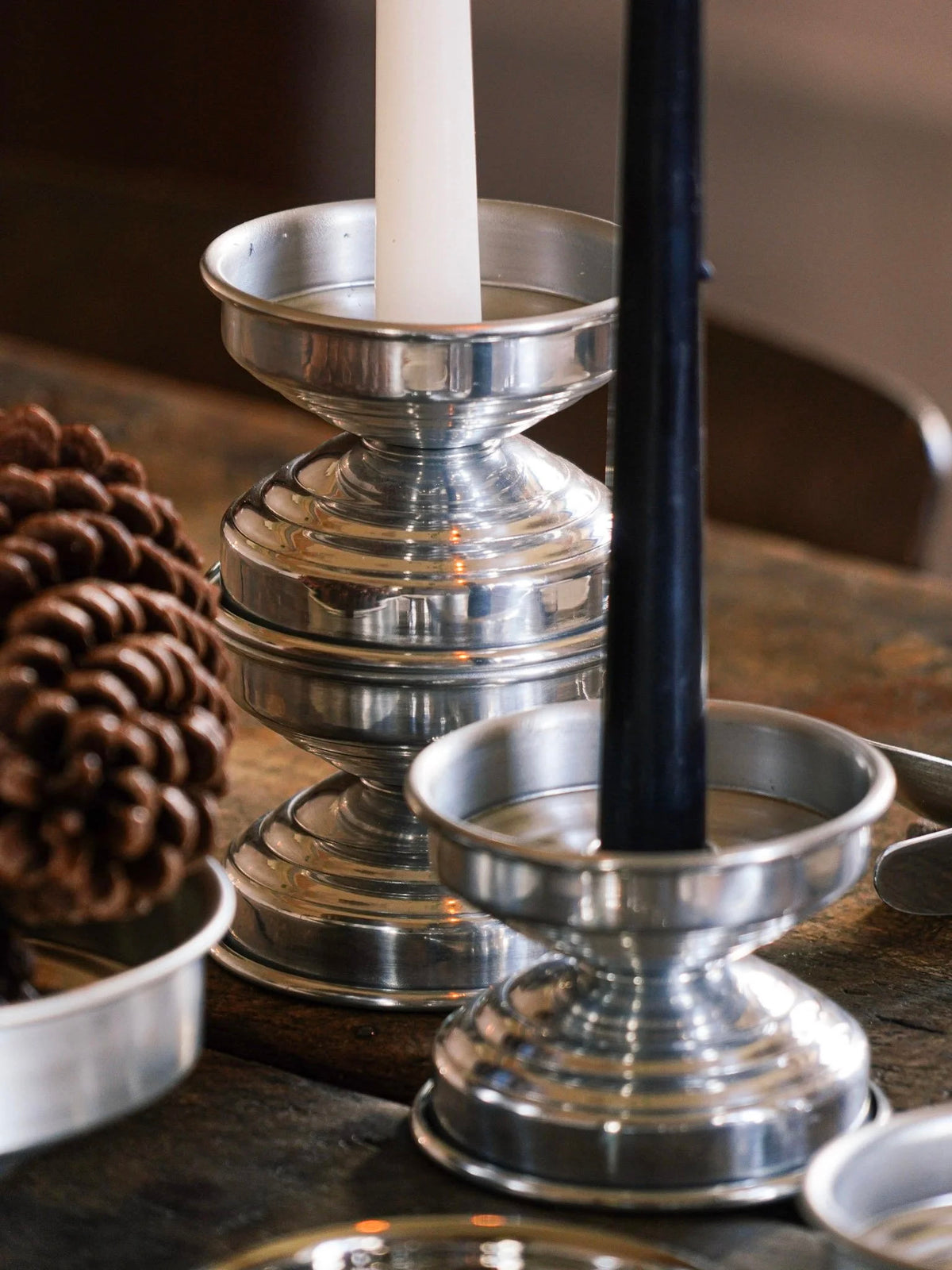Metal Candle Holders in Polished Aluminum — close-up on rustic wooden table