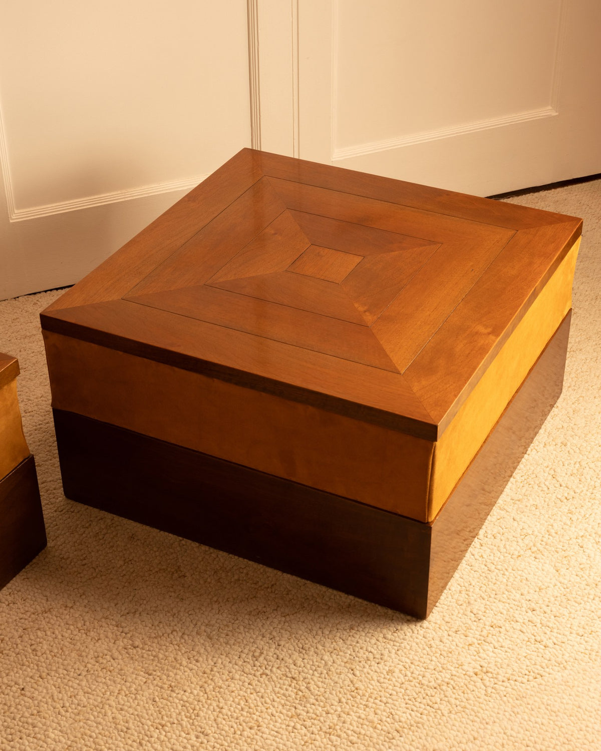 Detail view of stepped wood coffee table with geometric inlay pattern
