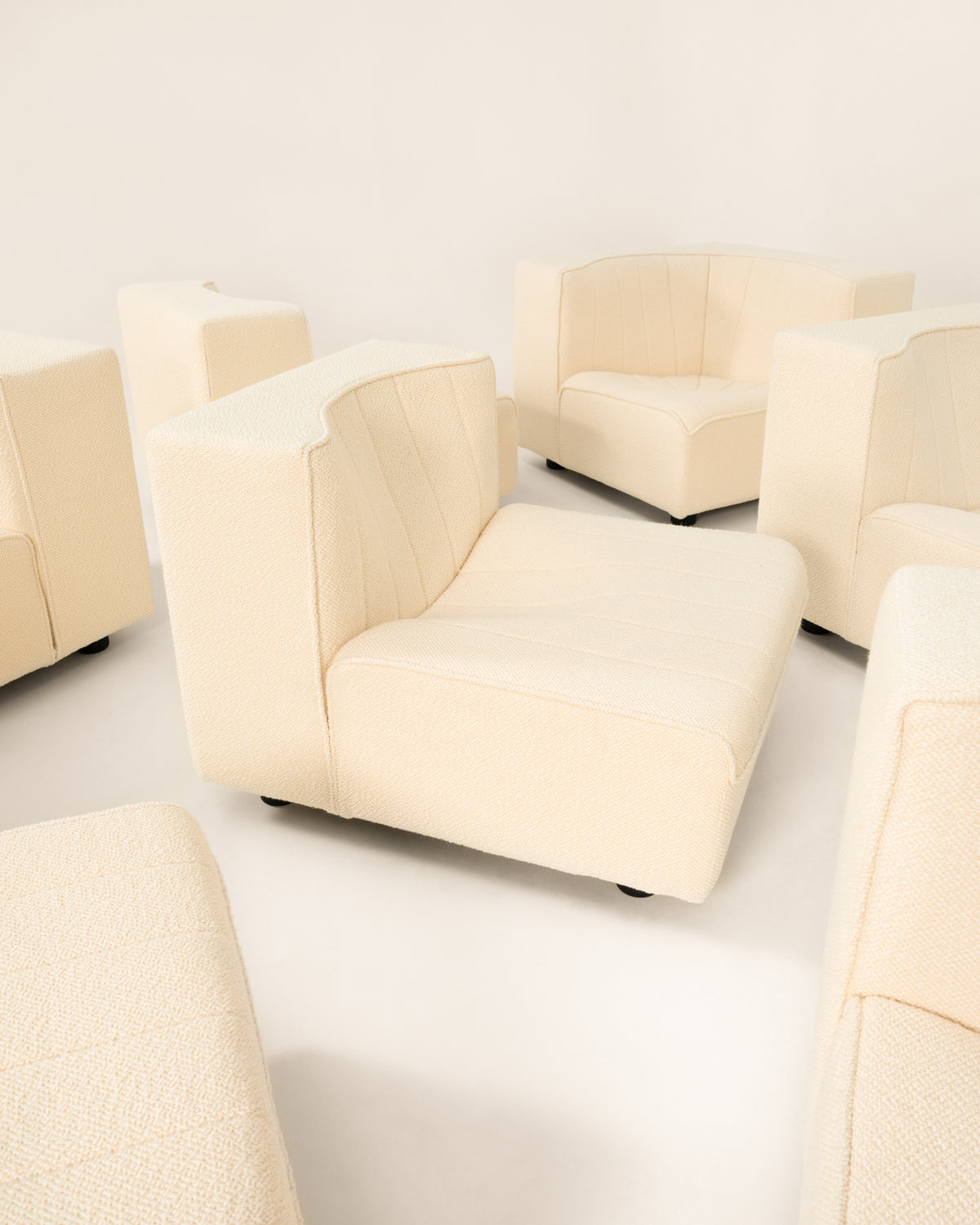 Cream modular sofa sections arranged on white floor display