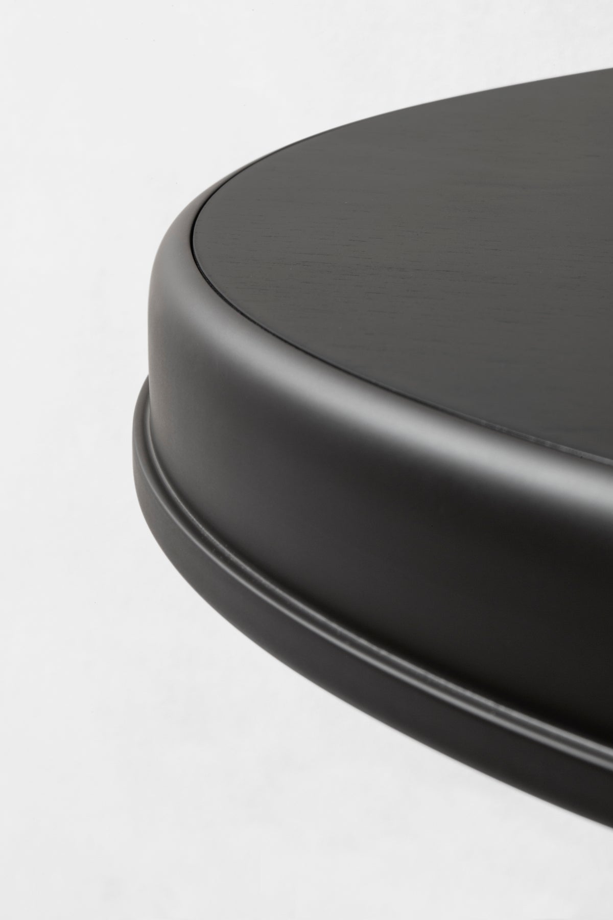 Round table curved edge detail in dark brushed finish