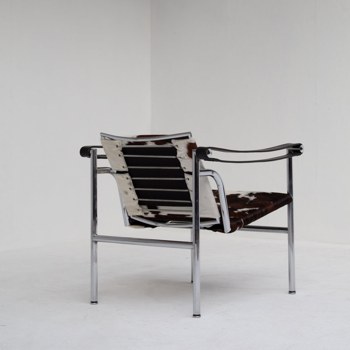 Le Corbusier, Pierre Jeanneret, Charlotte Perriand LC1 Chairs by Cassina — rear view highlighting cowhide seat and chrome fra