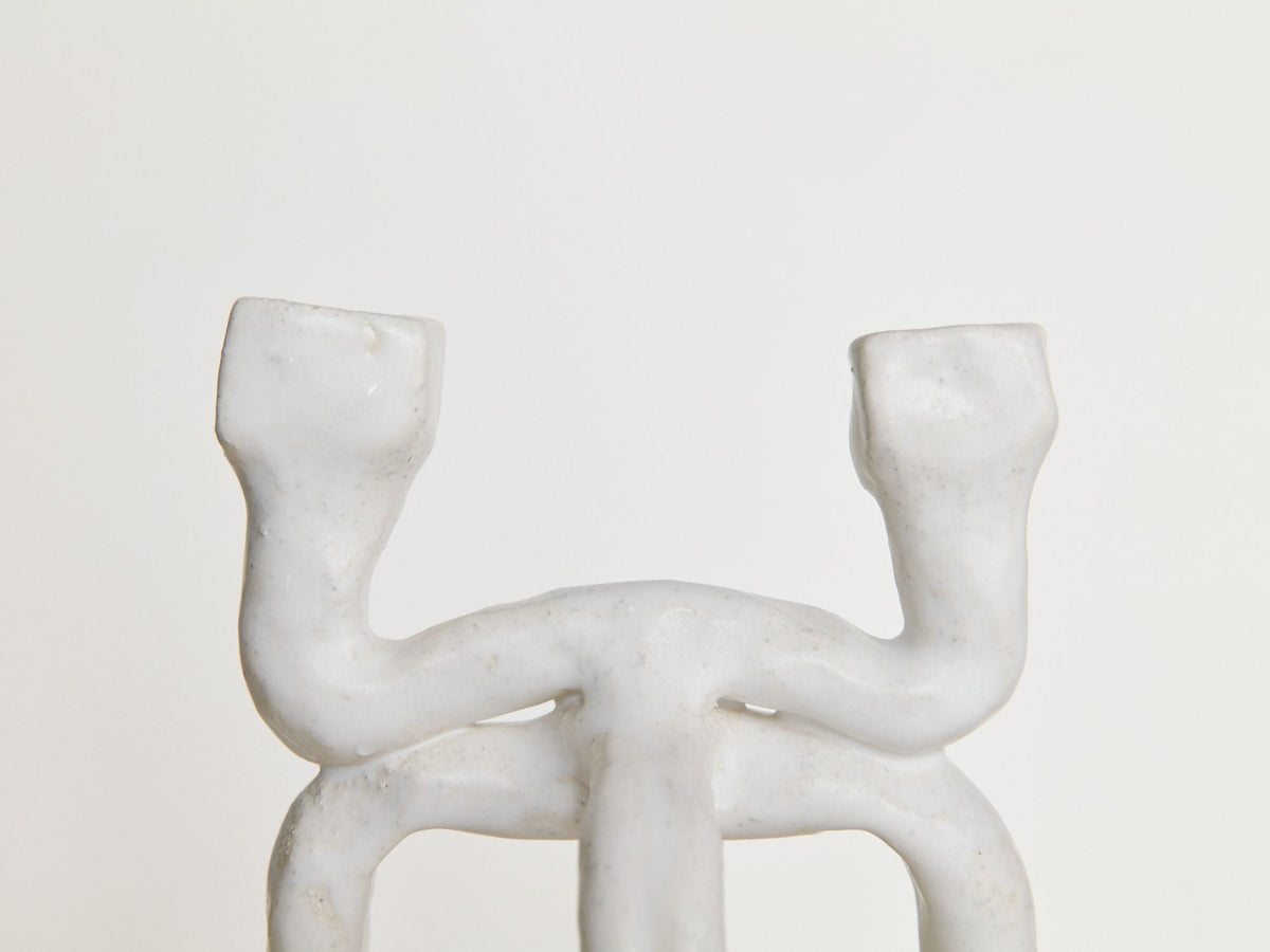 Close-up of Candleholder La Chose 2 by Claire Pain, crafted in white chamotte stoneware with two curved, upward branches. Its subtly textured surface offers a unique touch—ideal as elegant home decor or a stylish candle holder.