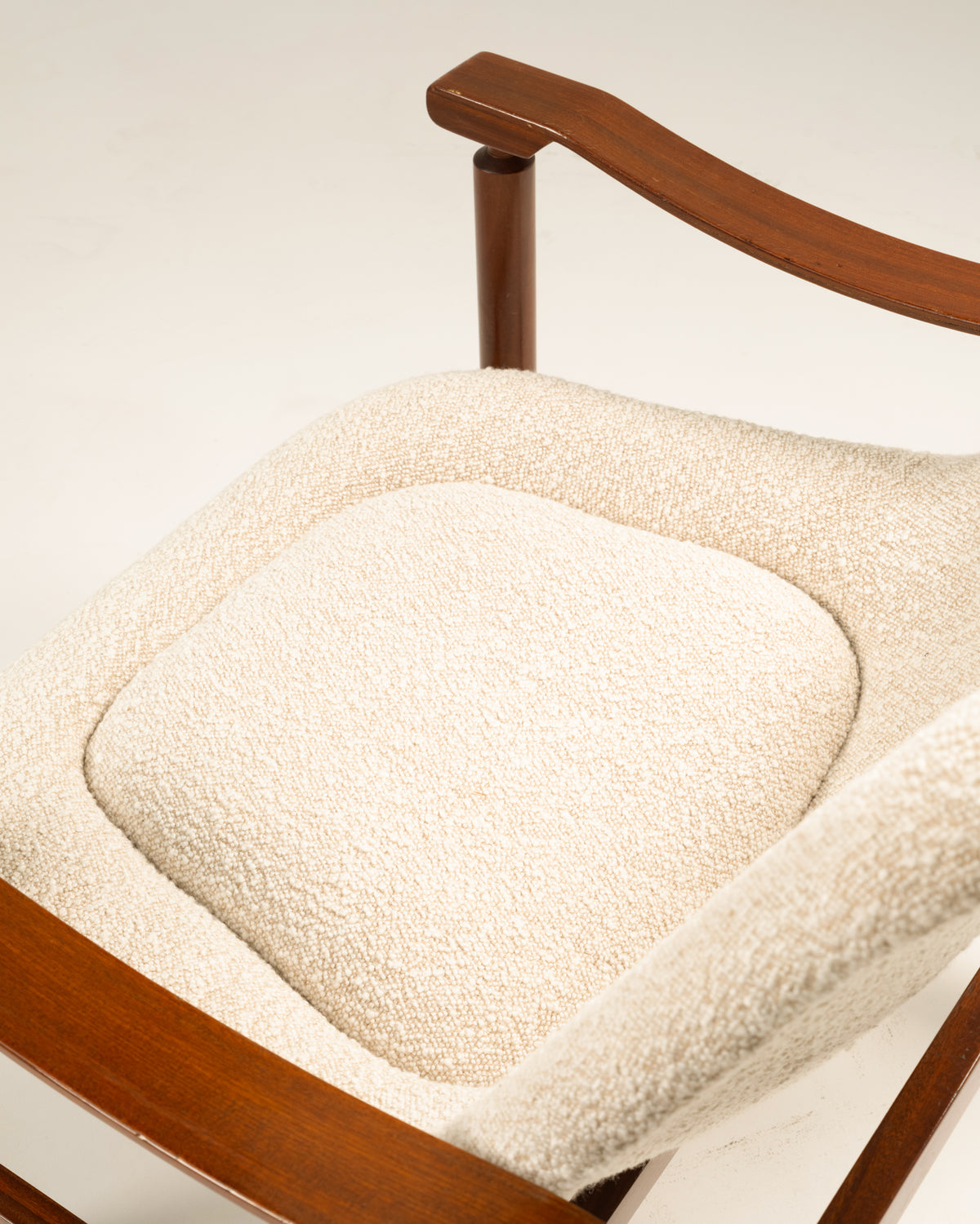 Close-up of cream bouclé upholstery on Tiki armchair seat