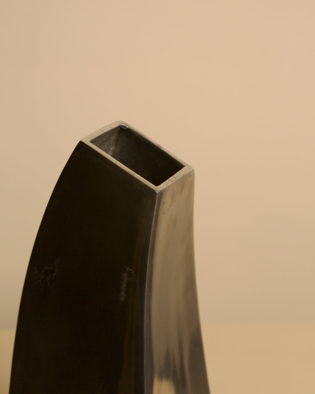 Corne vase in cast aluminum, 80s — close-up of angular top edge