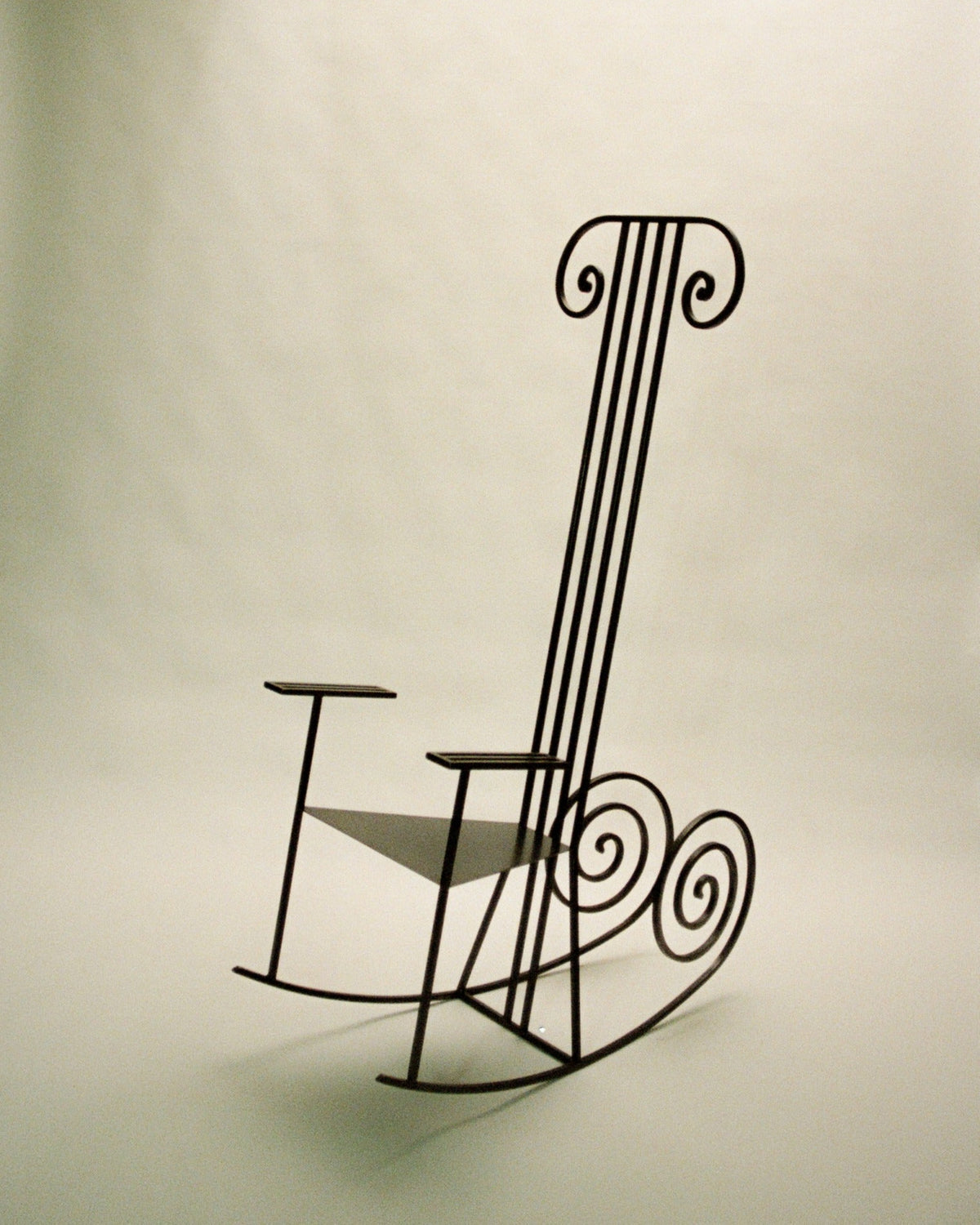 Minimalist wire rocking chair with sculptural spiral backrest
