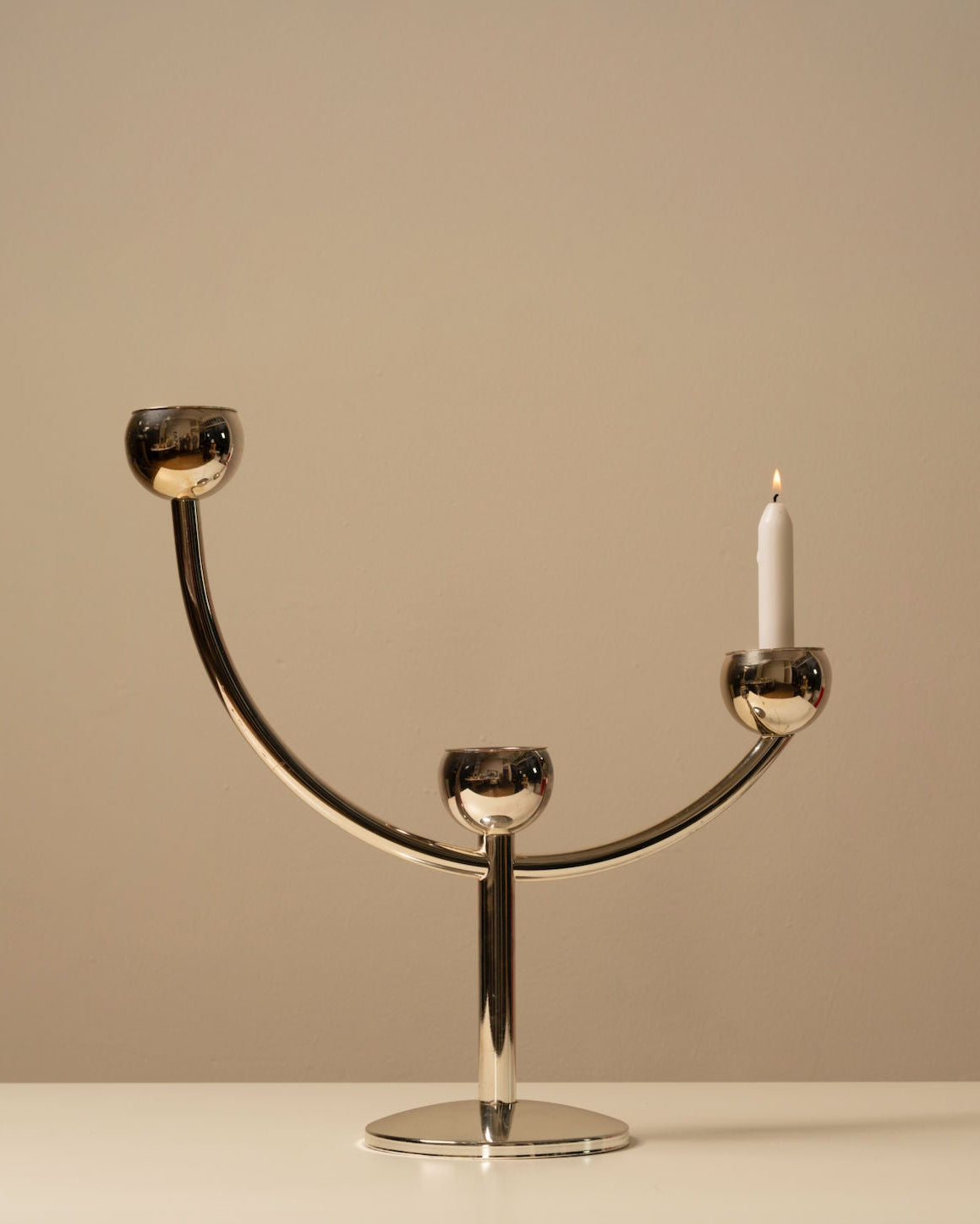 Vintage modernist chrome candleholder with three holders and lit candle