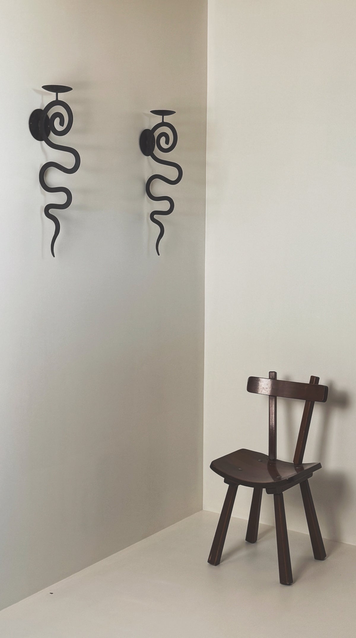 Large antique wall sconces with serpentine iron design and candle holders