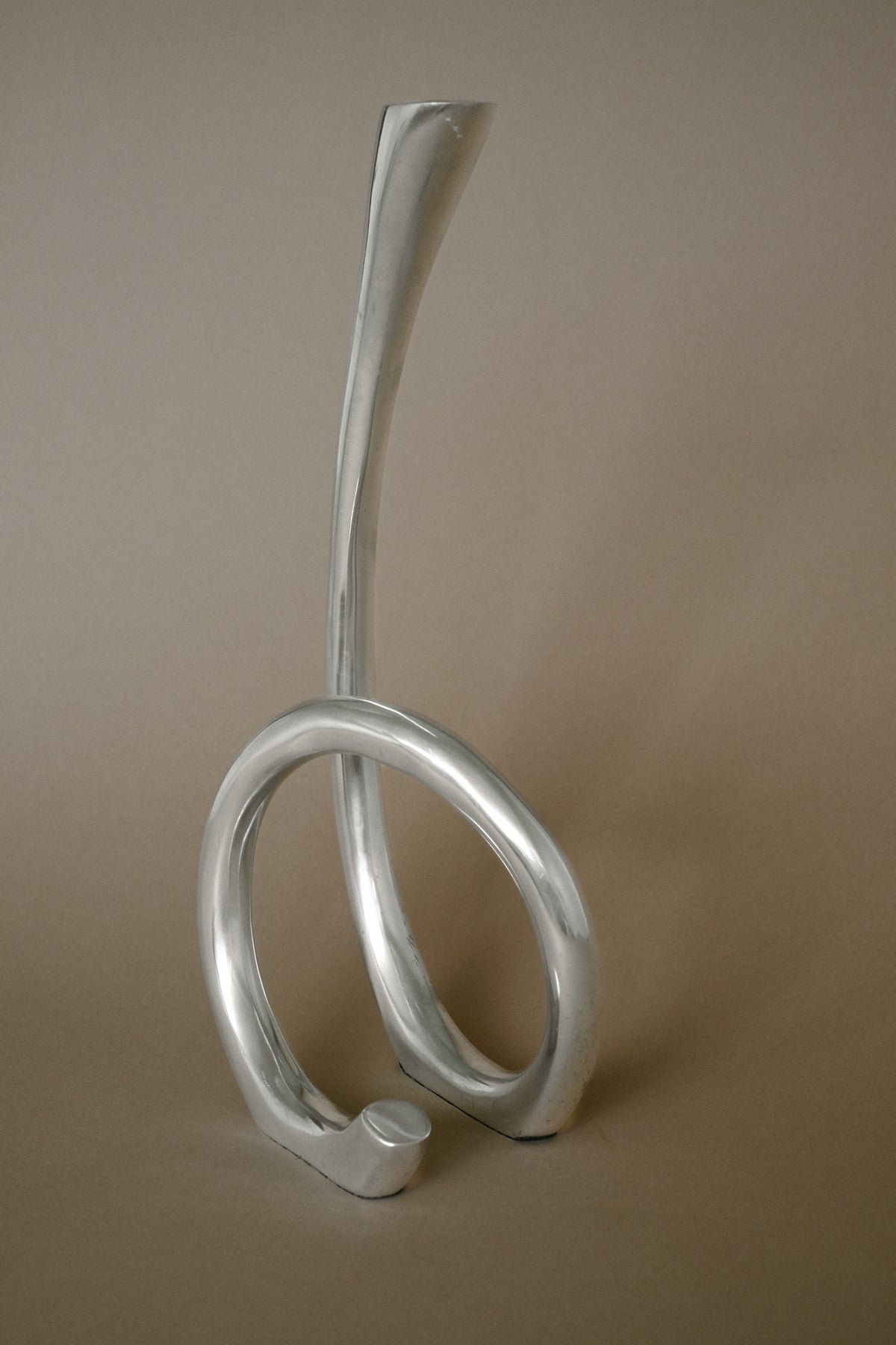Modern silver candleholder with curved sculptural base design