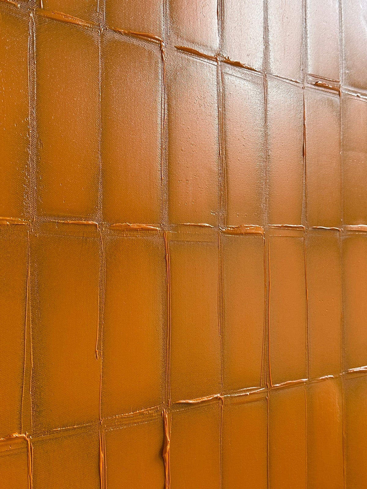 Close-up detail of orange painted grid texture on canvas
