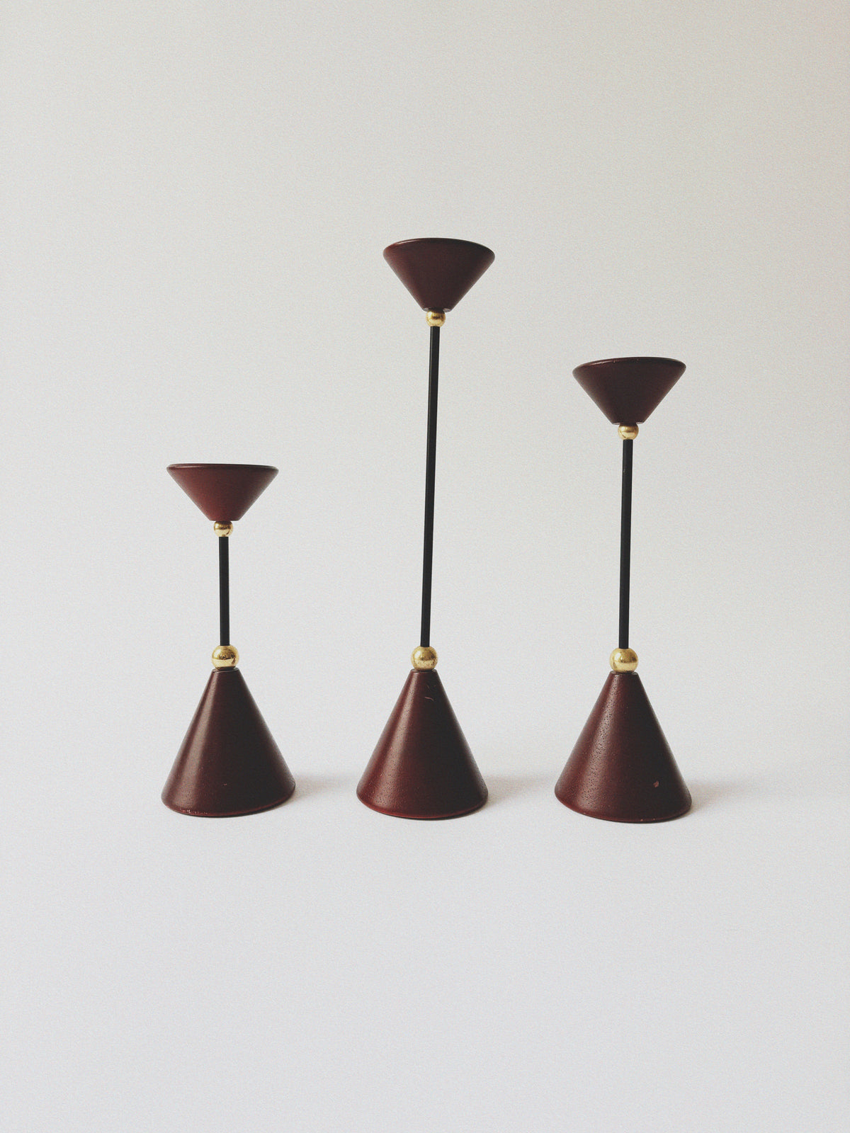 Set of Postmodern Candle Holders in Wood and Metal — close-up of red cone shapes with black stems