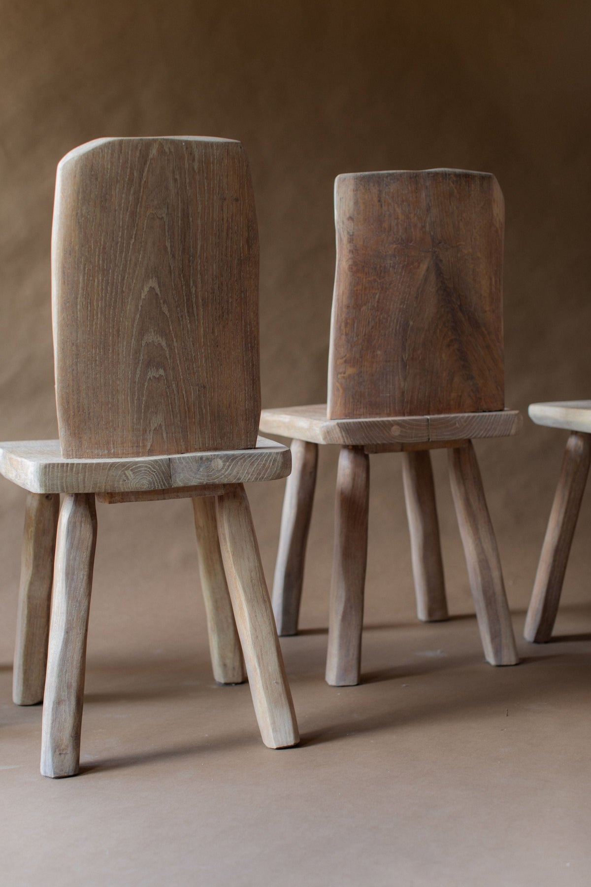 Two rustic wooden dining chairs with natural wood grain detail