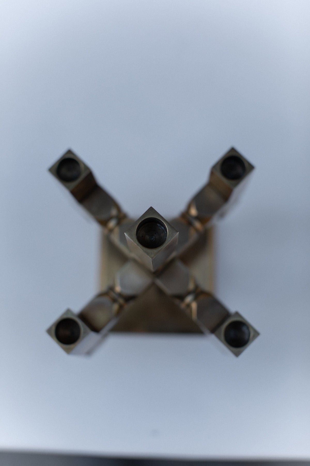 Bottom view of brutalist brass candleholder showing geometric design