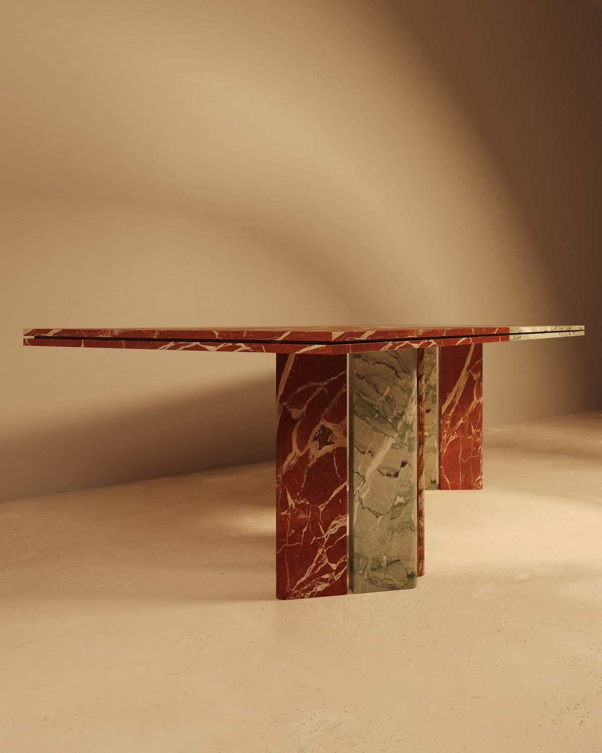 Marble dining table with red and green veined base on beige background