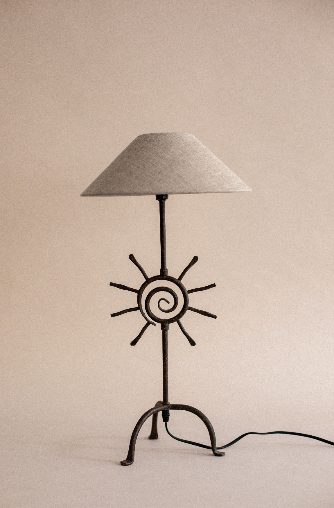 Bari table lamp with sun motif base and conical linen shade