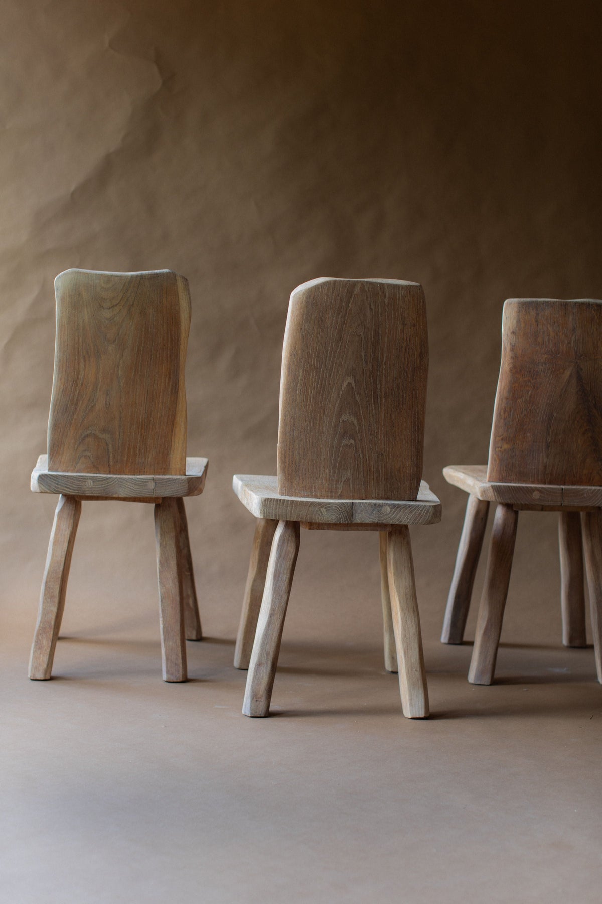 Three brutalist oak chairs showcasing natural wood grain texture