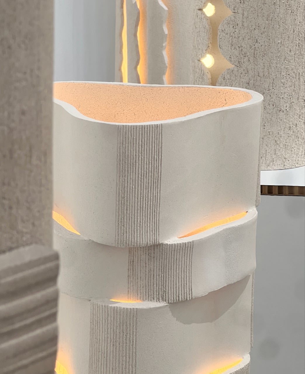 White ceramic floor lamp with ribbed texture and warm LED lighting accents