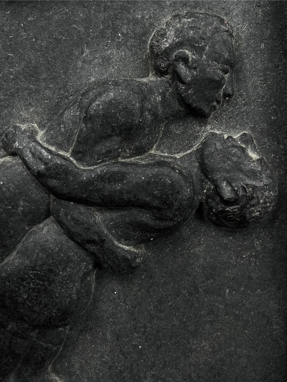 Wrestlers, Relief Sculpture in Stone — close-up of dark stone texture
