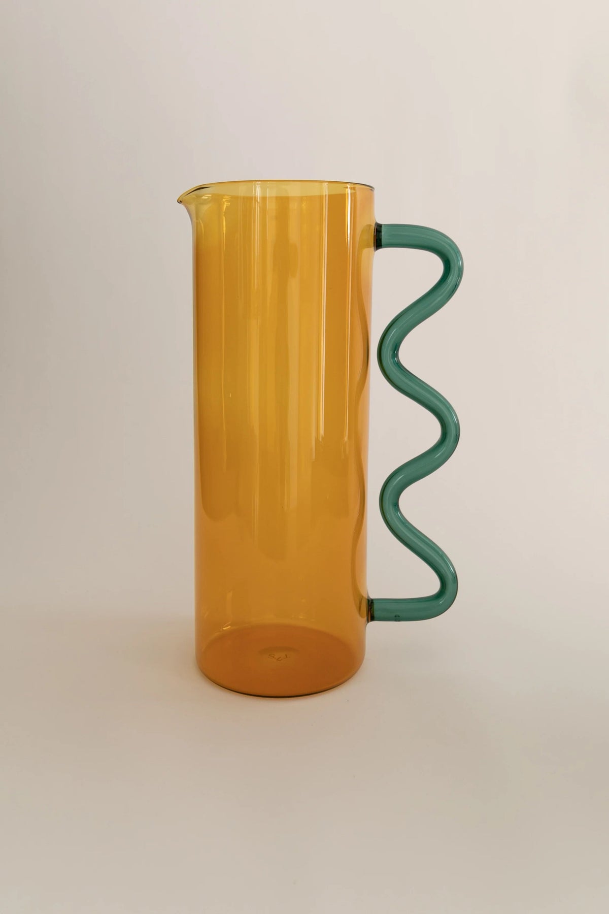 Wave Pitcher — side view with amber body and green handle