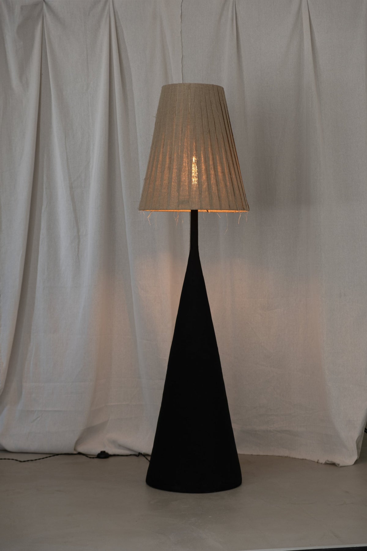 VERETENO Floor Lamp — back view with textured black base and linen shade