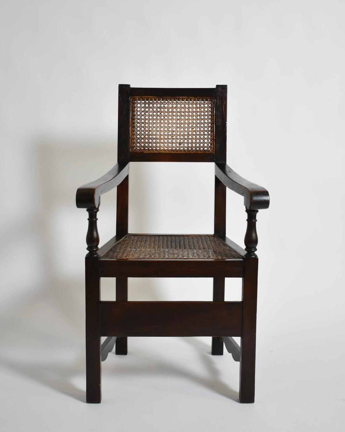 Pair of turned wood and cane armchairs, 1910s — front view highlighting cane seat and wooden frame