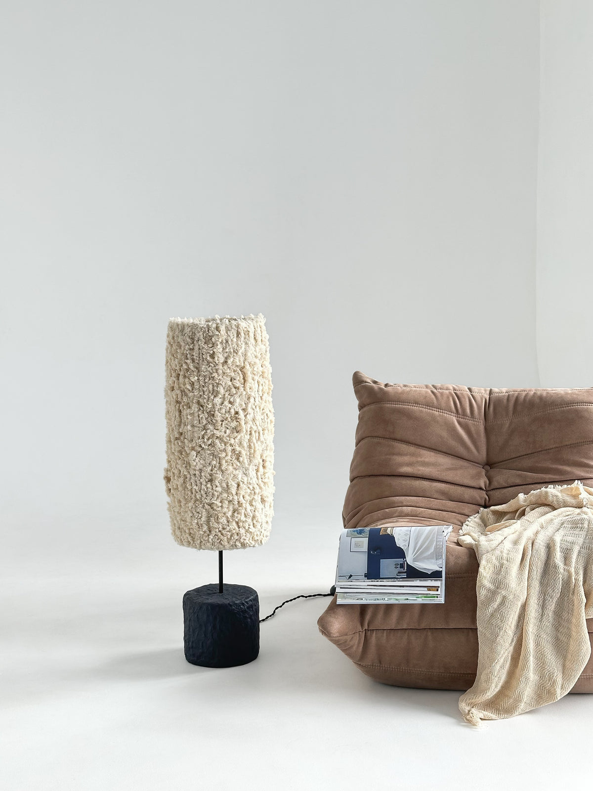 Bavo Sculptural Floor Lamp — placed beside plush beige sofa in minimalist setting