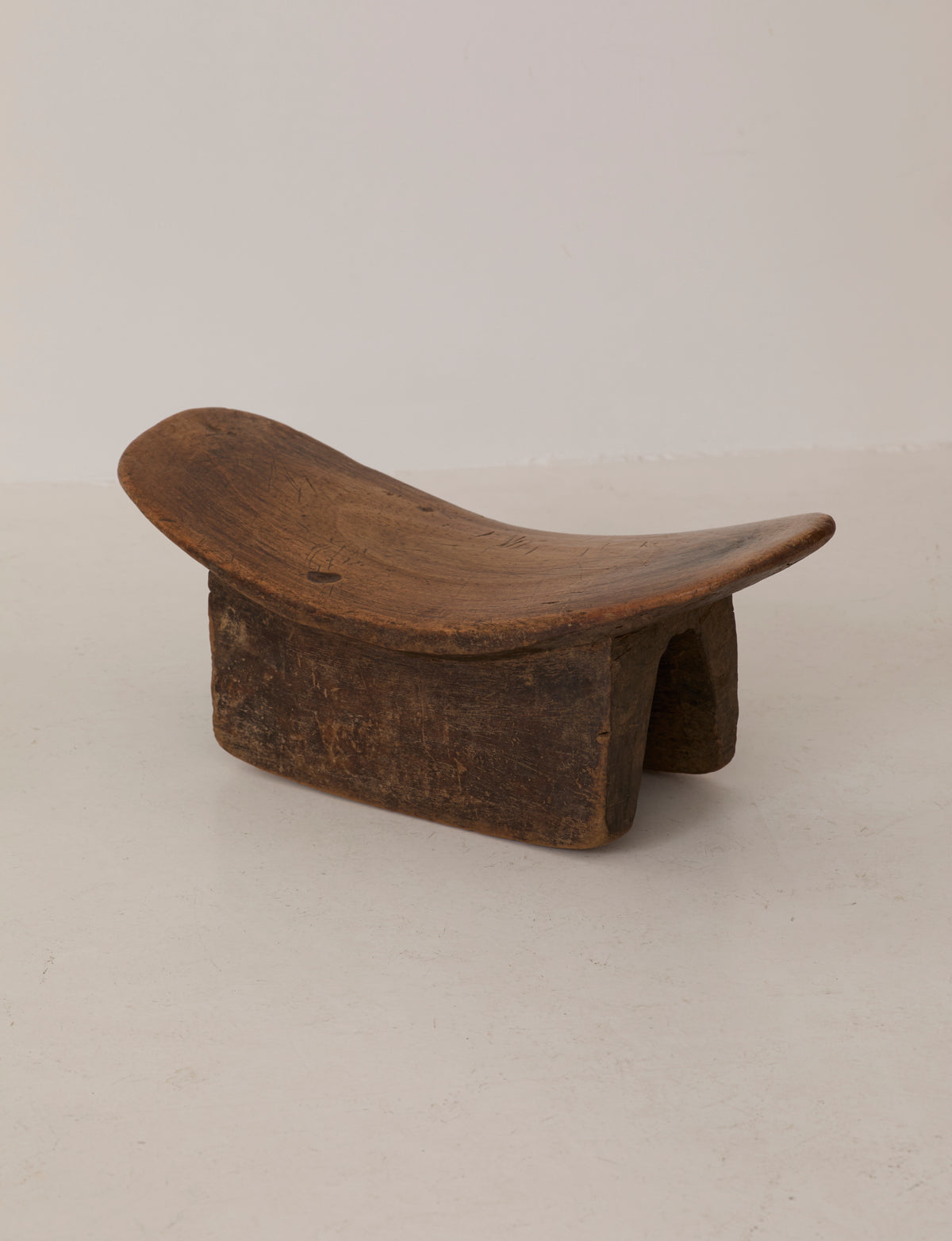 Mid-Century African Senufo Stool in Solid Wood — side angle showing curved wooden seat