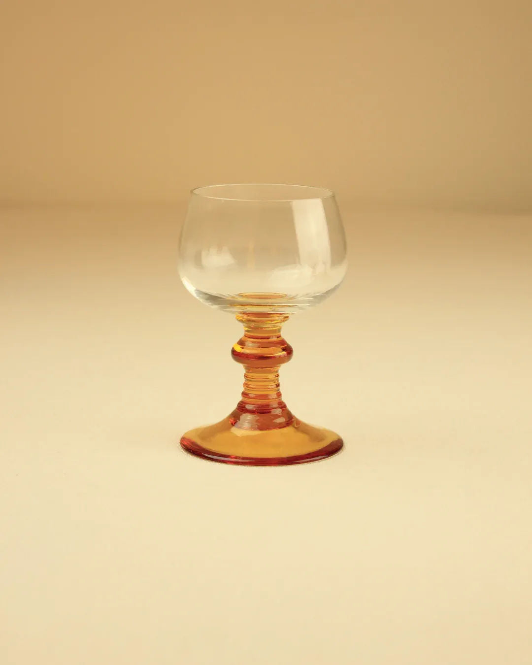  Close-up of two Roemer glasses showing intricate gold detailing on the stem and base 