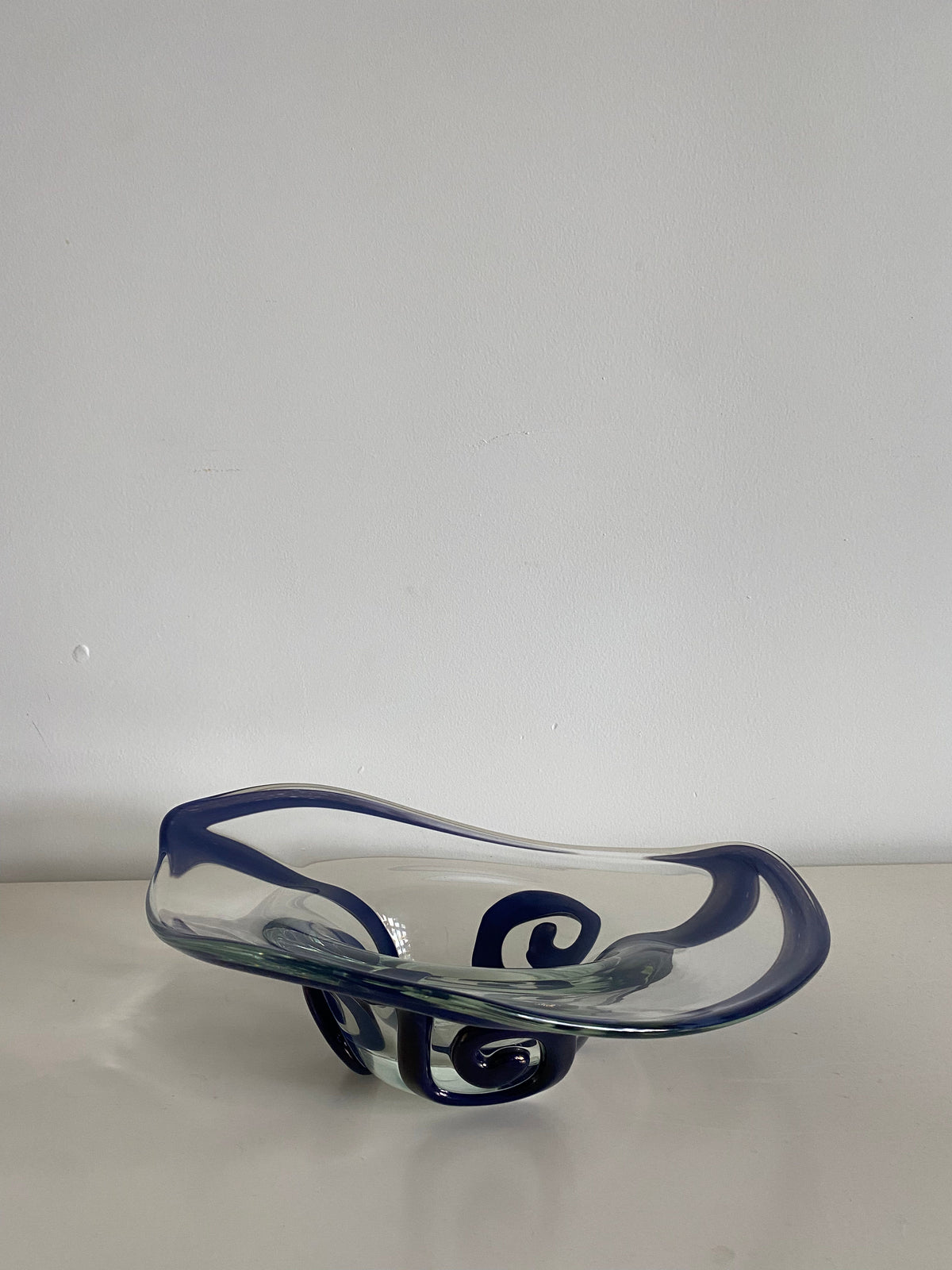 A decorative glass bowl with exquisite craftsmanship, featuring blue swirl designs on a white surface against a light grey background, the 1998's Czech Bowl by Les Objets Amsterdam.