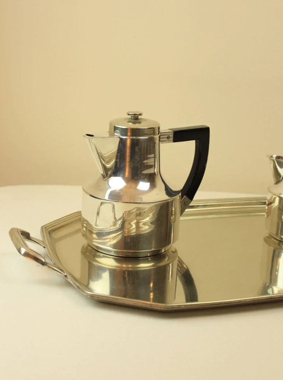 An elegant Art Deco coffee and tea set with intricate silver designs and matching serving tray