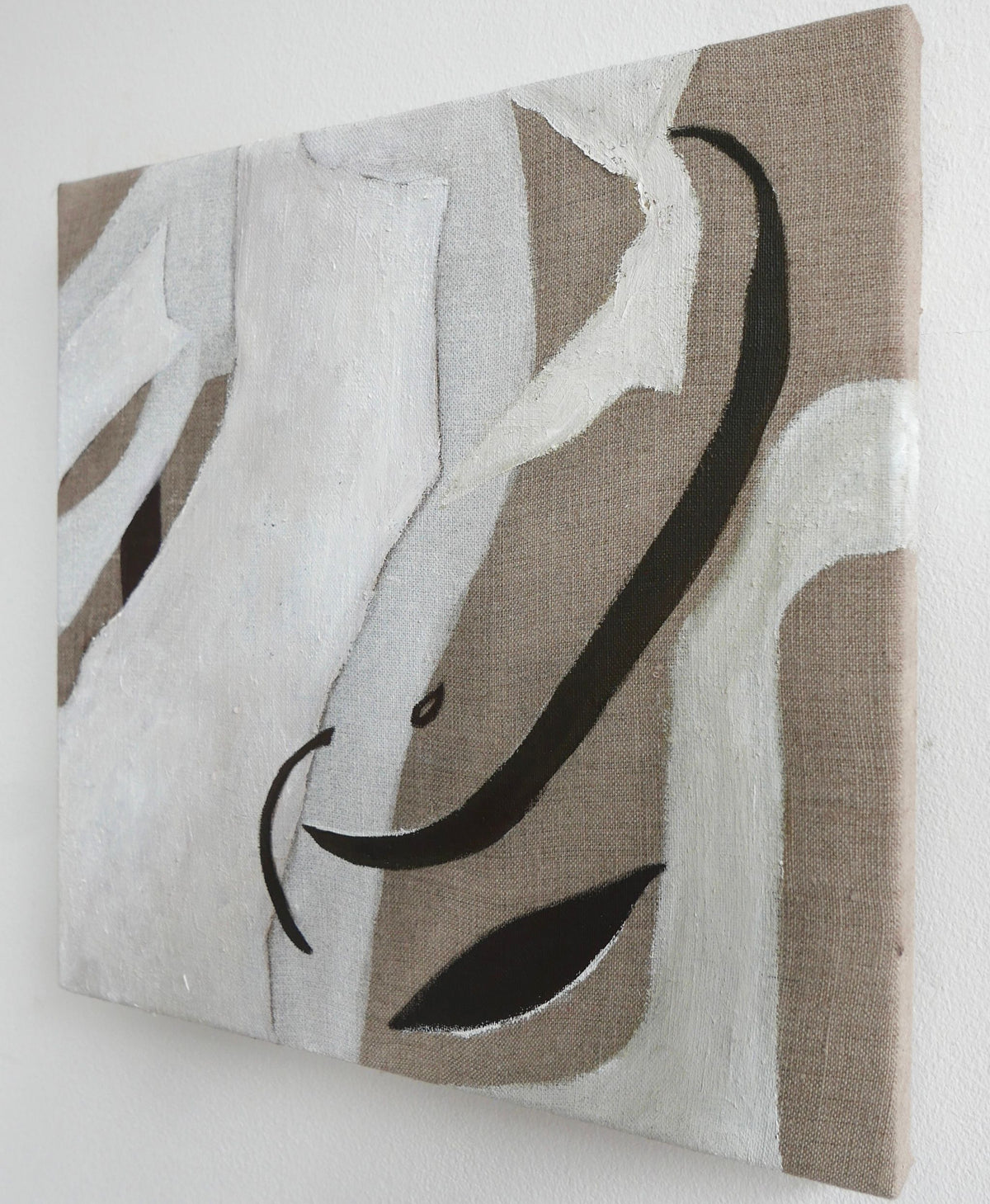 Abstract oil paint canvas featuring curved black lines and white shapes on a textured beige background, displayed on a white wall by Elena Barber's 'Silk Light'.