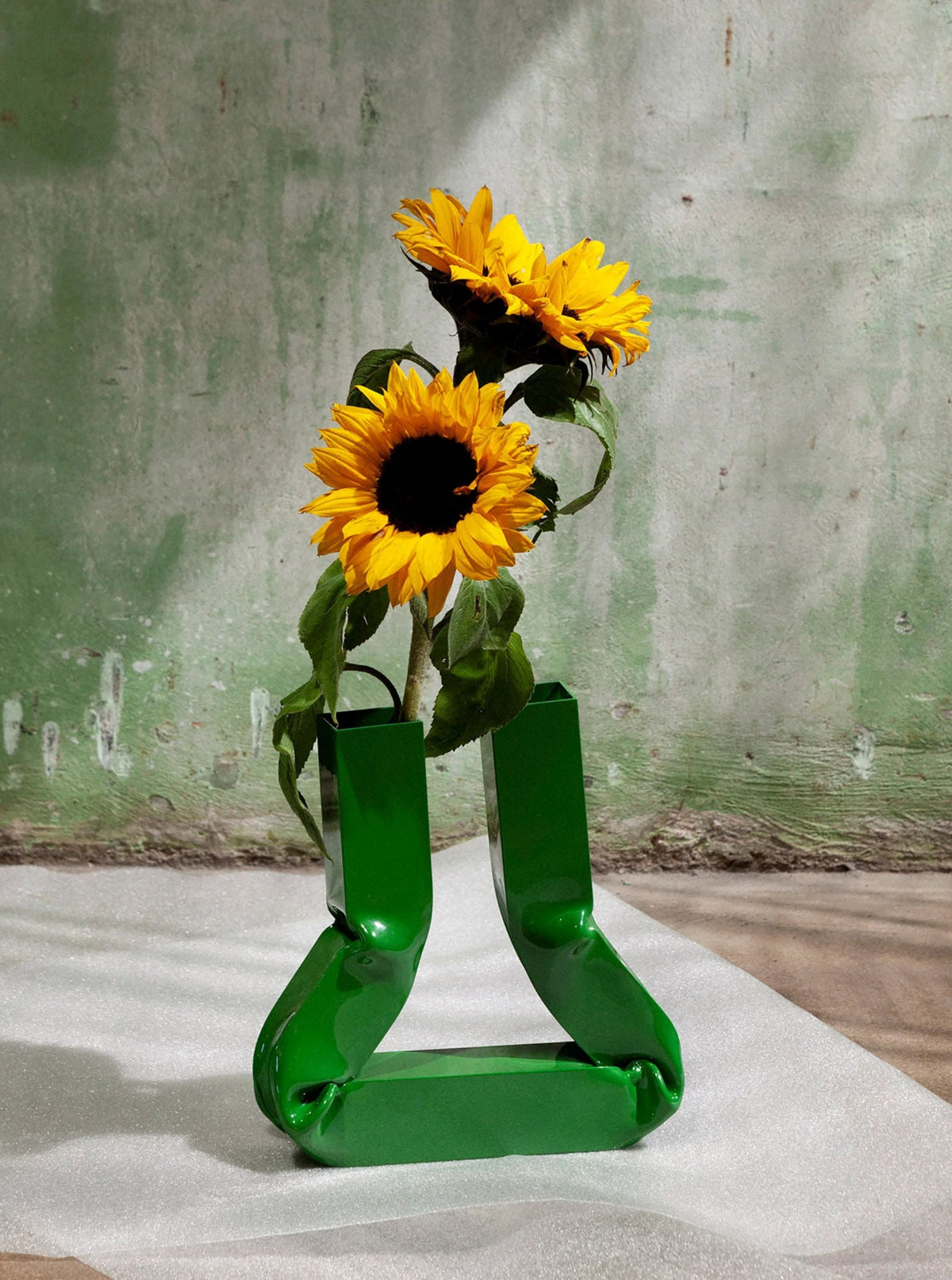Vasi Vase (Grass Green) sitting on a wooden table with flowers in it