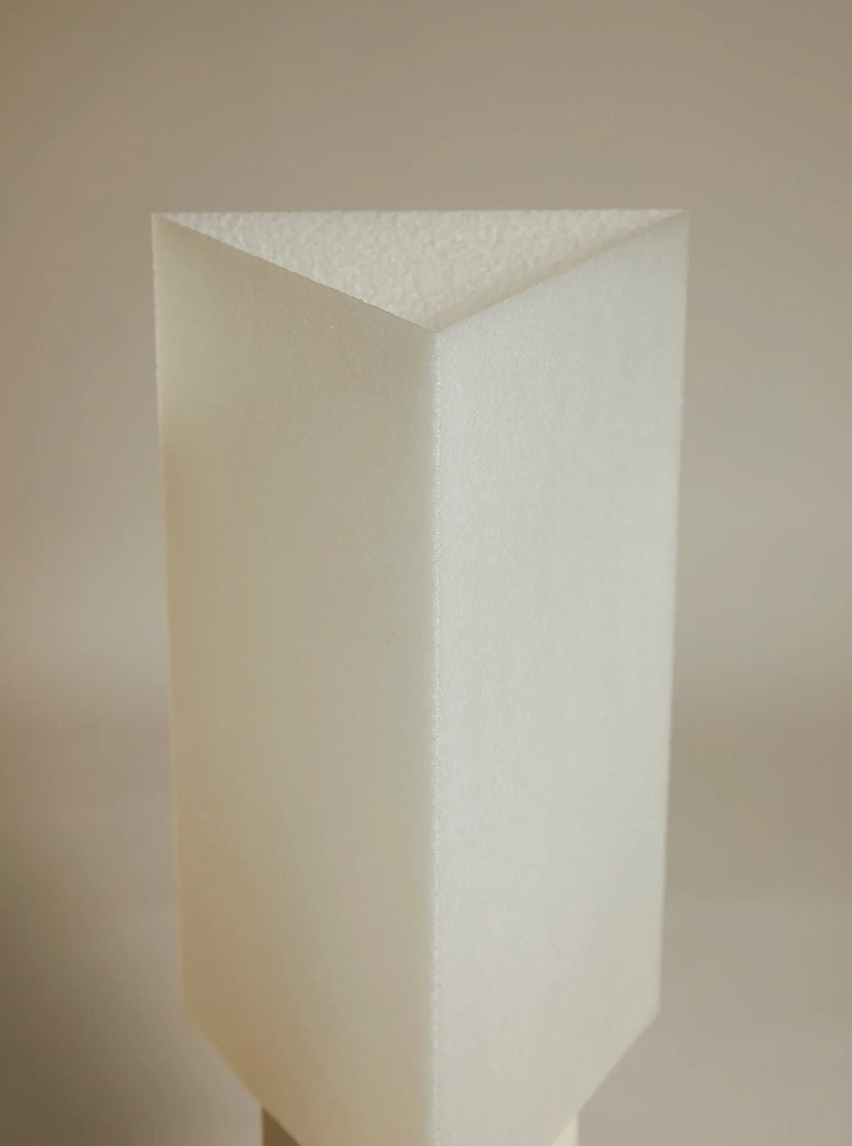 A close-up image of a Lampe ii foam corner protector by Argot Studio, embodying minimalist Japanese design, showing the texture and geometric shapes of the material against a neutral background.
