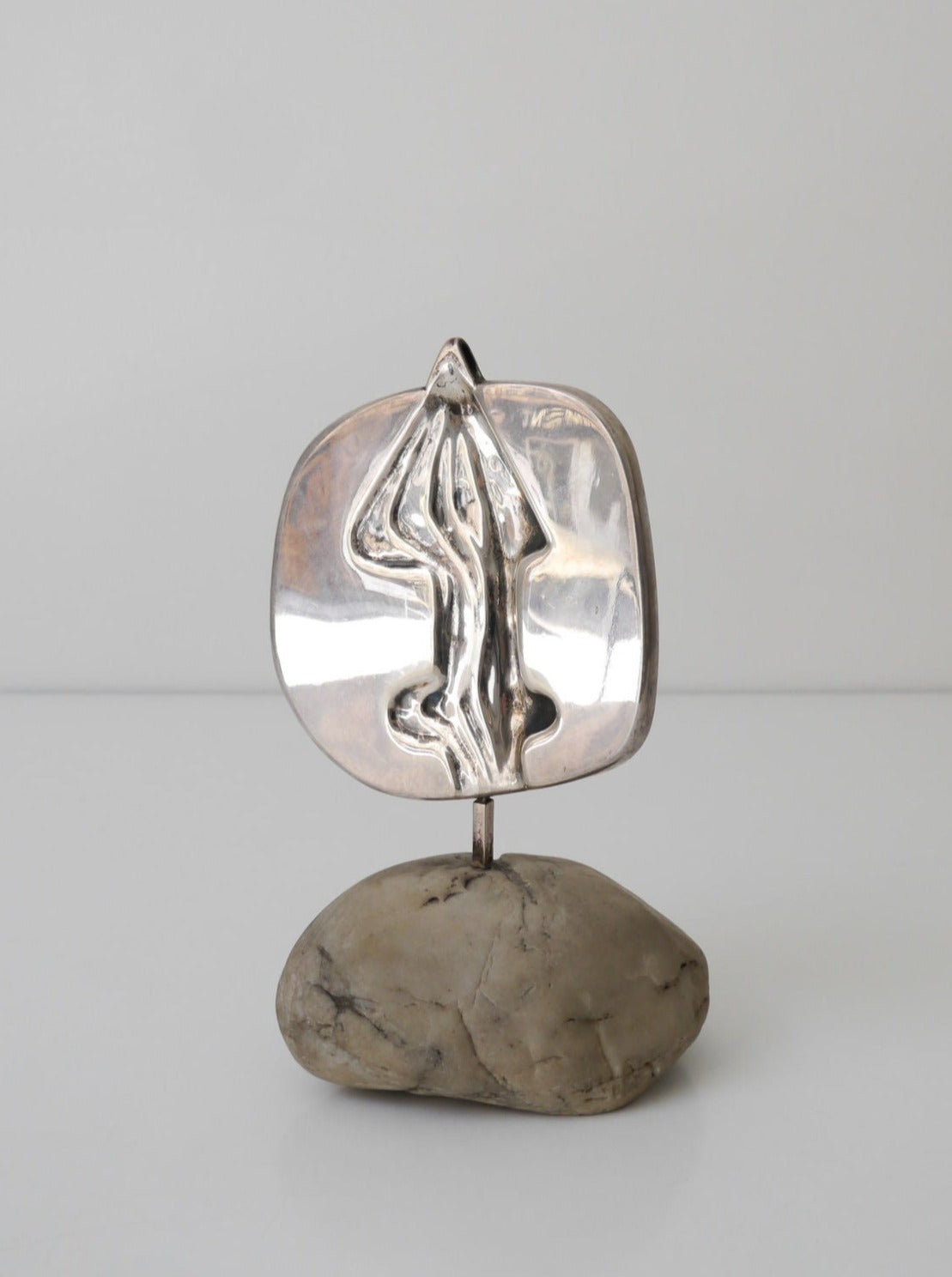 Collection apart De Vecchi Milano Silver Sculpture, resembling a tree, mounted on a smooth, beige stone base, displayed against a neutral background.