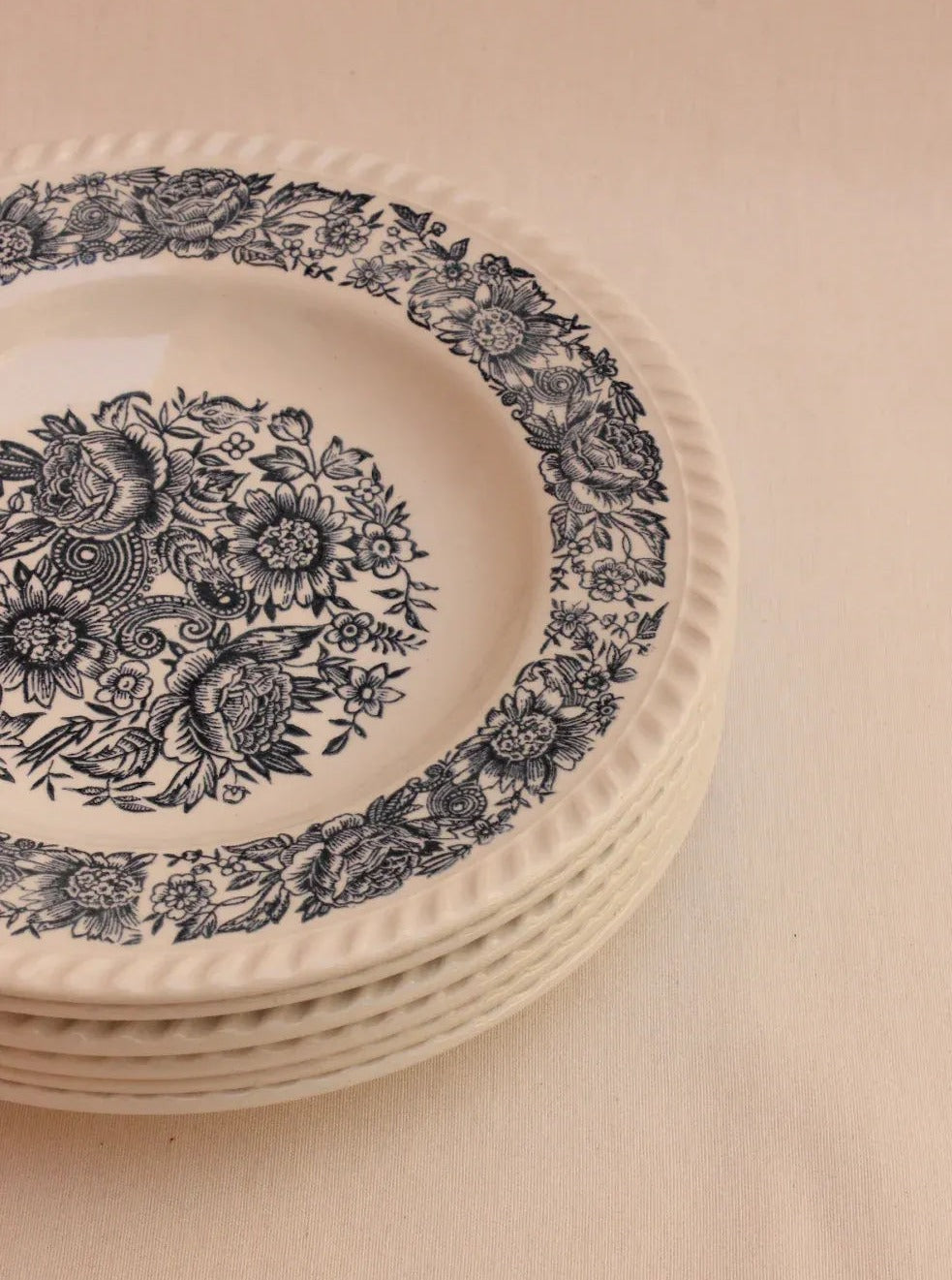  Close-up of a stack of elegant porcelain plates with intricate hand-painted details