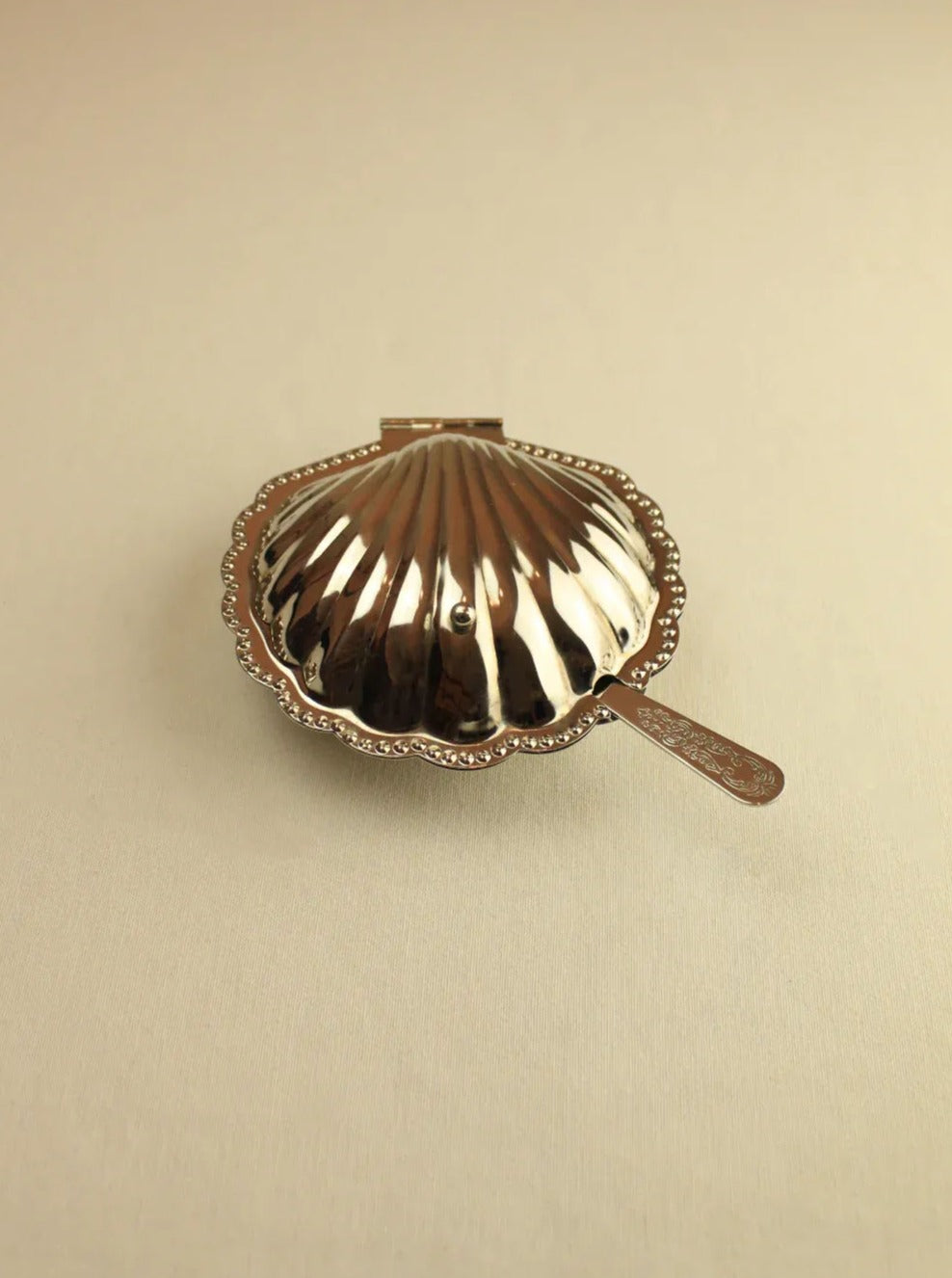 White ceramic shell-shaped butter dish with lid and scalloped edges