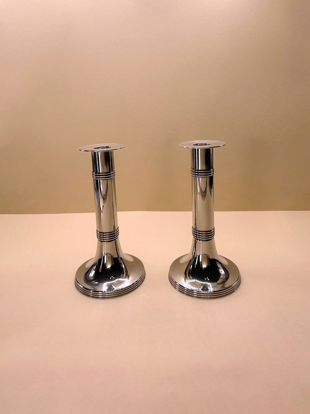 Pair of silver-plated candlesticks by Gunther Lambert, featuring intricate design and elegant curves